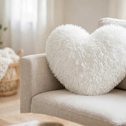 White fluffy heart pillow on a sofa